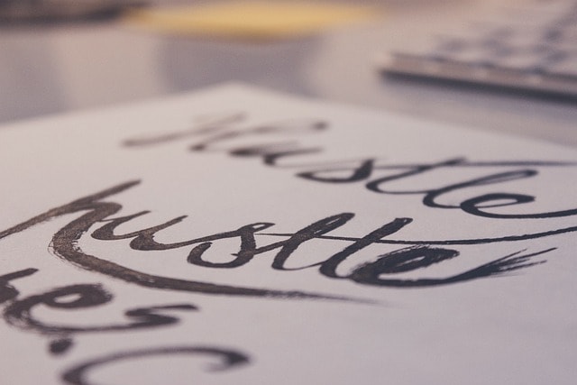 Lettering on paper with hustle word.
