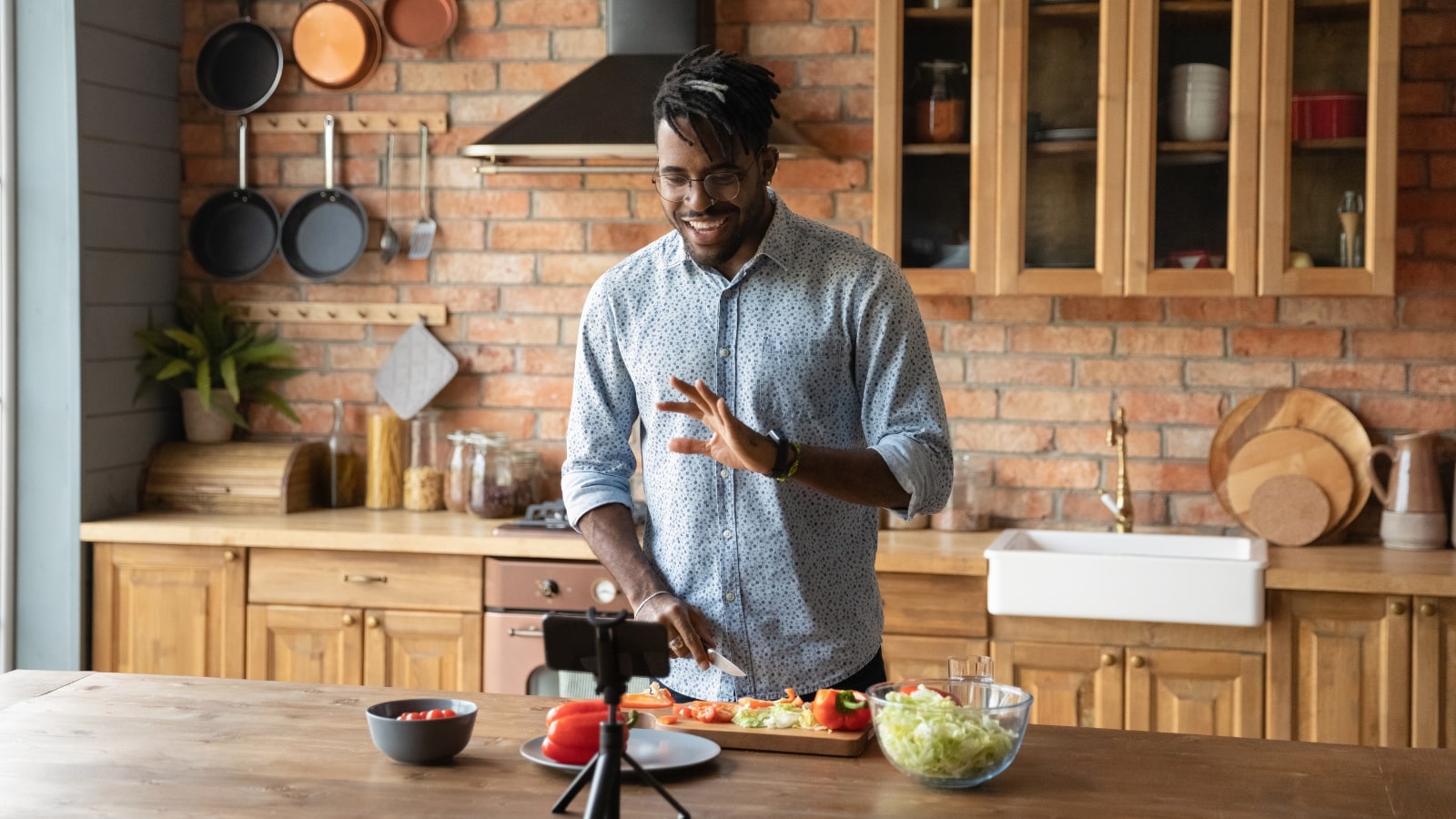 Male food blogger recording an episode using phone.