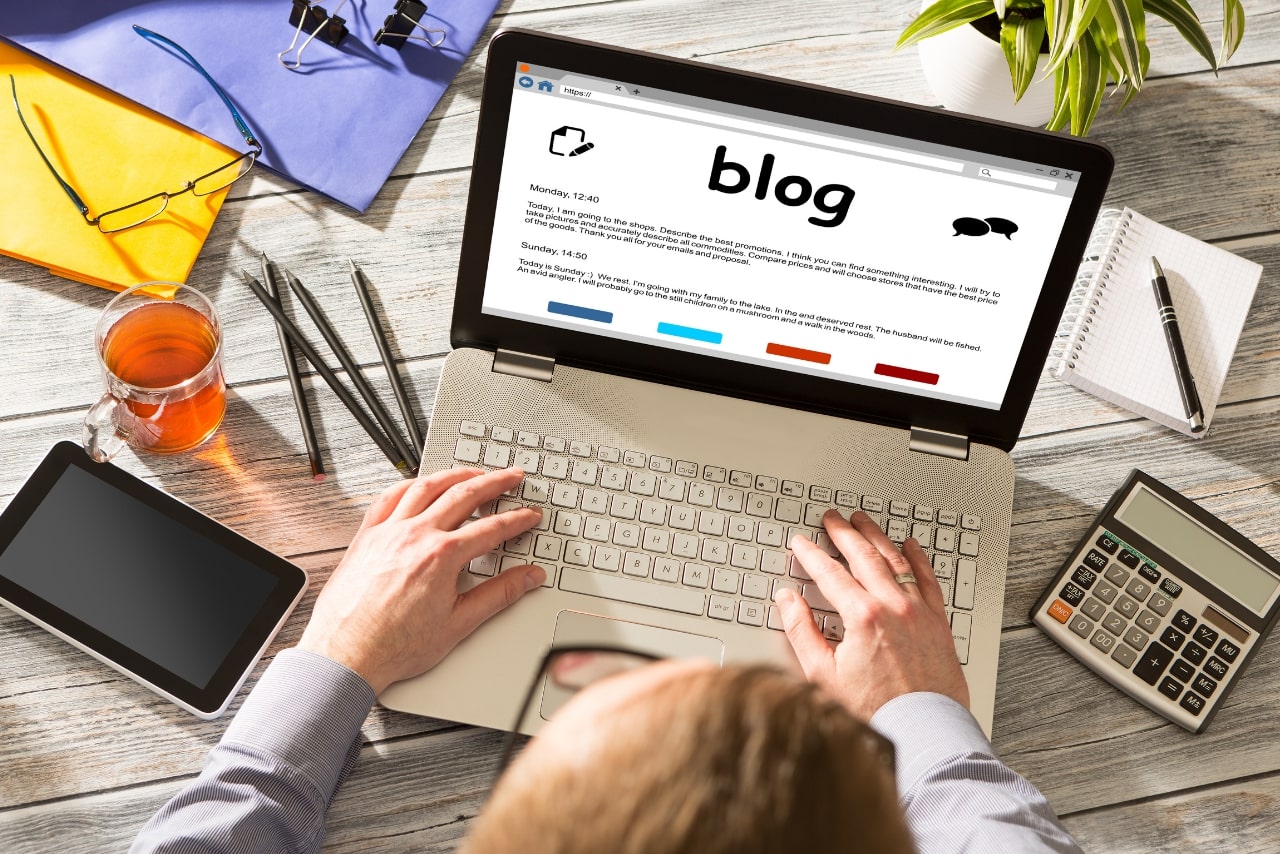 Male person typing blog post on his laptop.