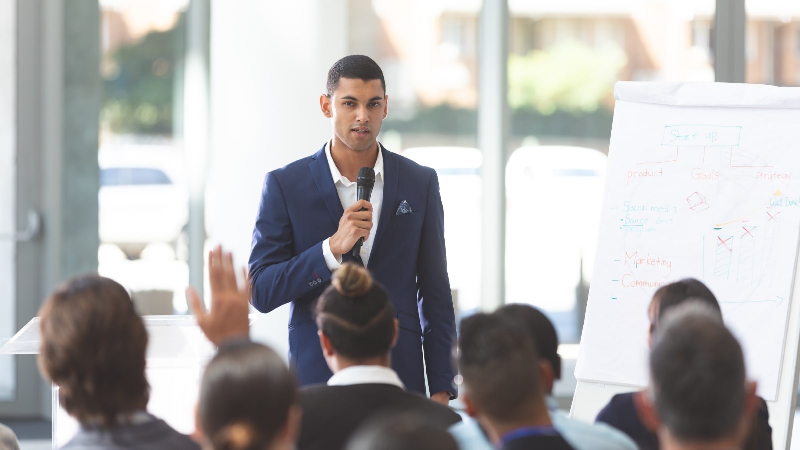 Male speaker speaking with microphone at conference.