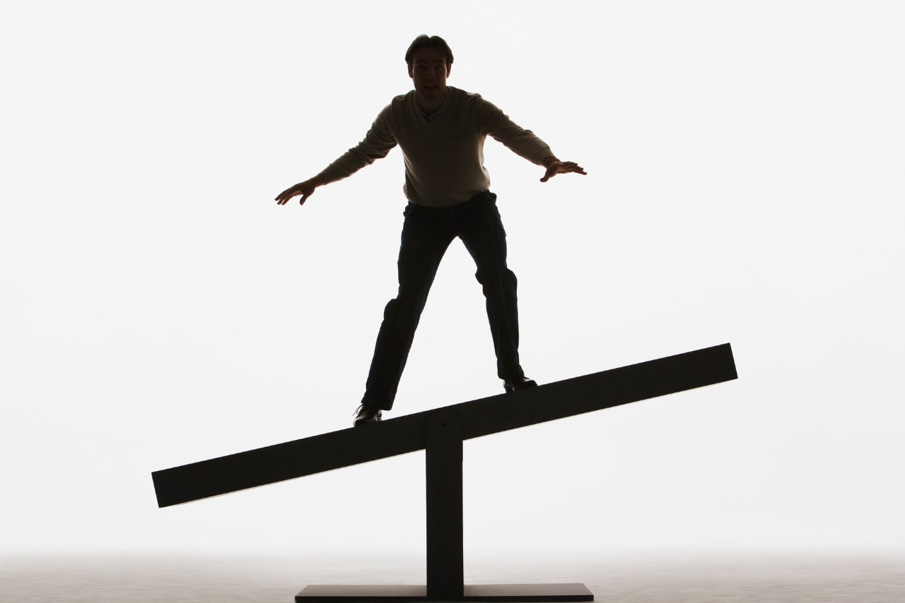 Man finding it difficult to balance on a plank.