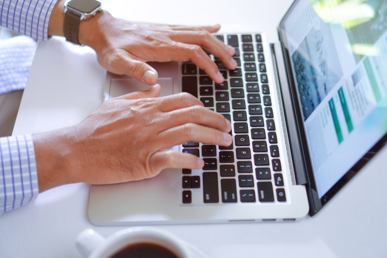 Man typing and editing written content on laptop.