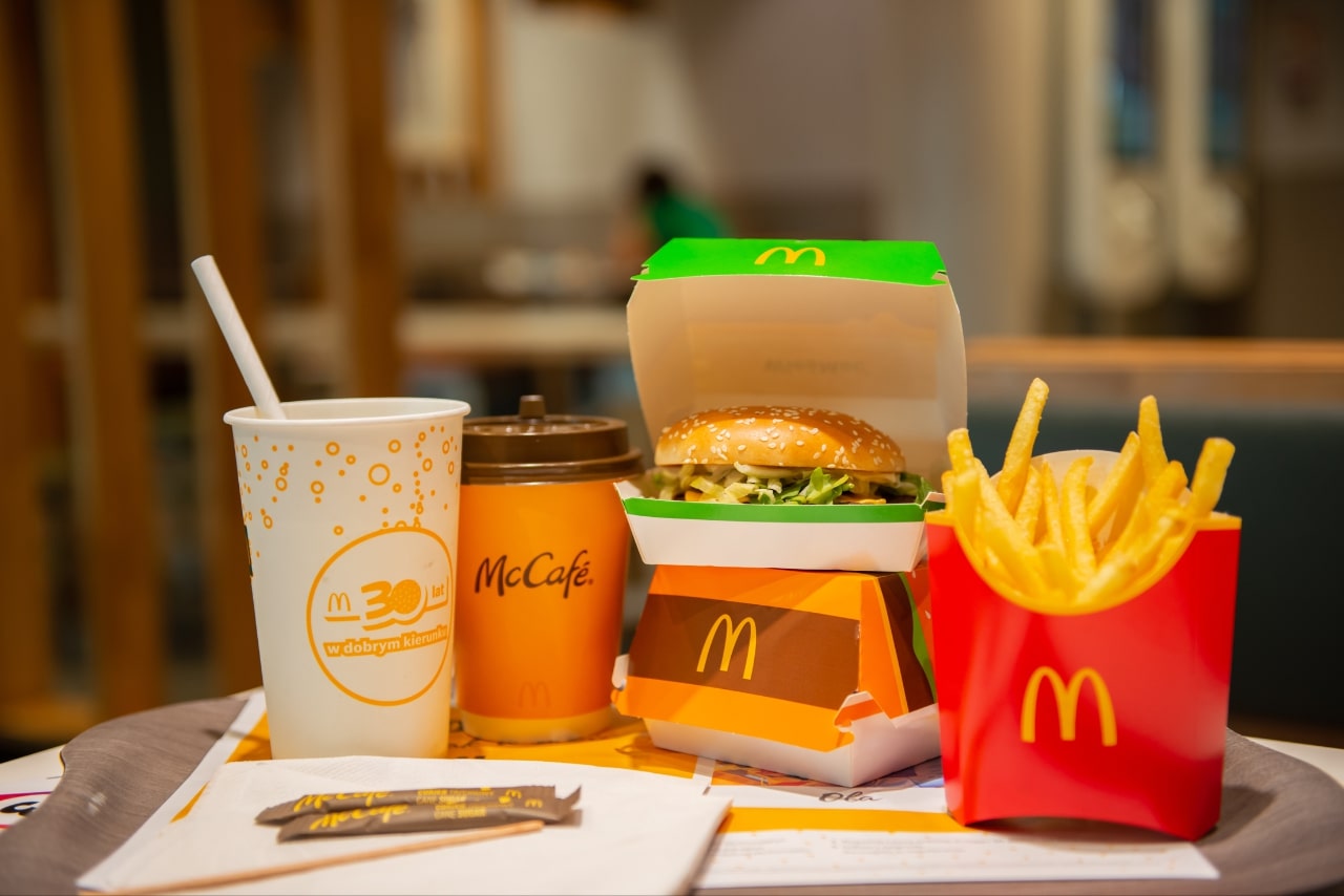 McDonald's French Fries, Burgers and Drinks on Table Indoors.