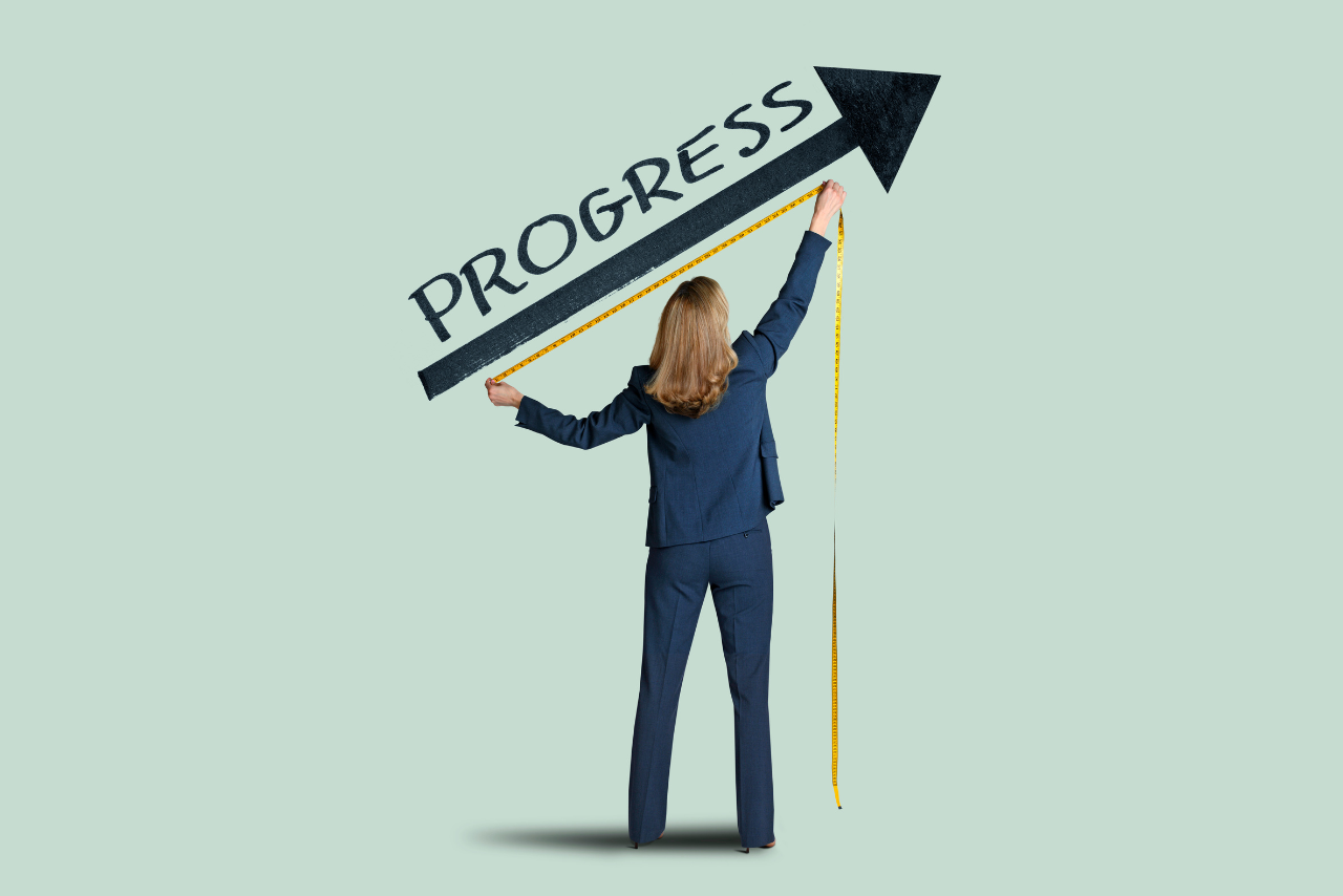 Rear view of business woman measuring success upward pointing arrow.