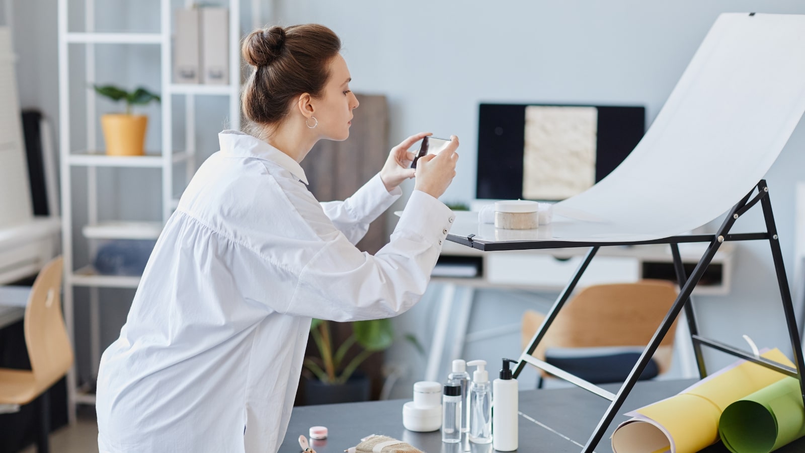 Sideview of woman taking photos of product using phone.