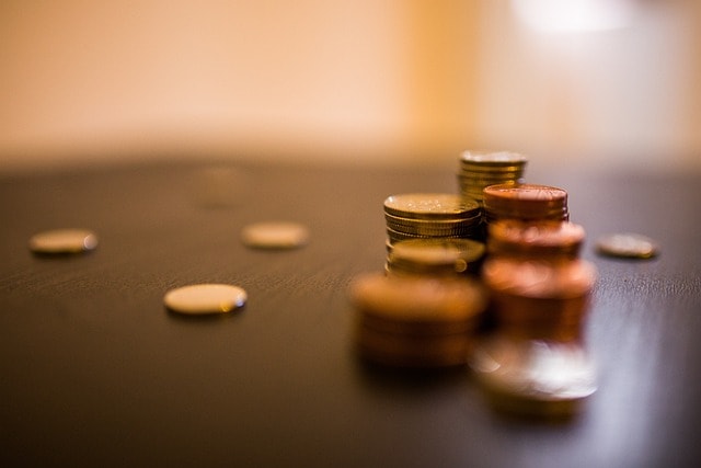 Stack of coins and pennies on table.