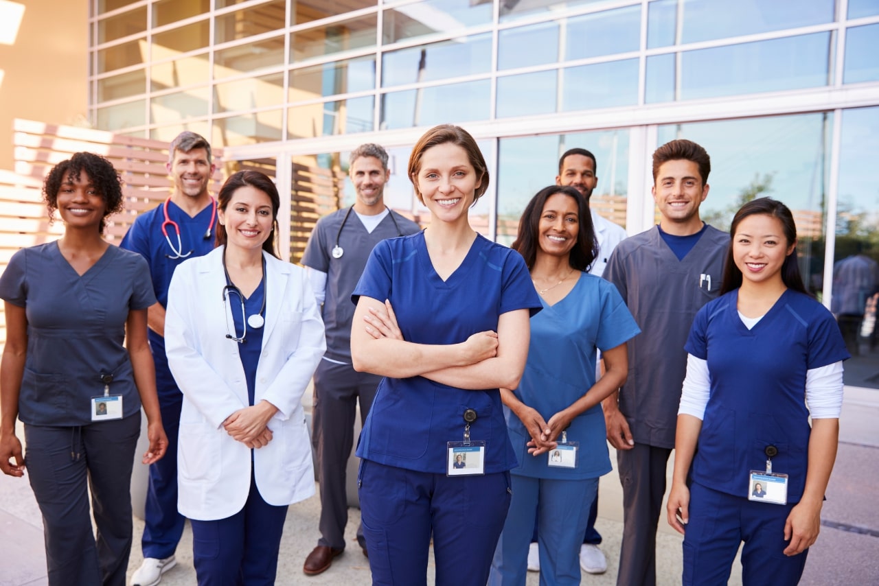 Team of Healthcare Workers with ID Badges outside Hospital.
