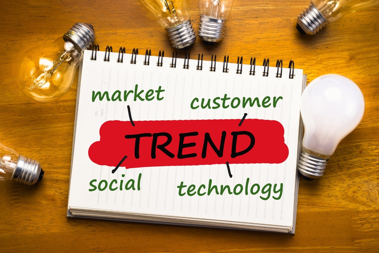 Trend concept on notebook with glowing light bulb.