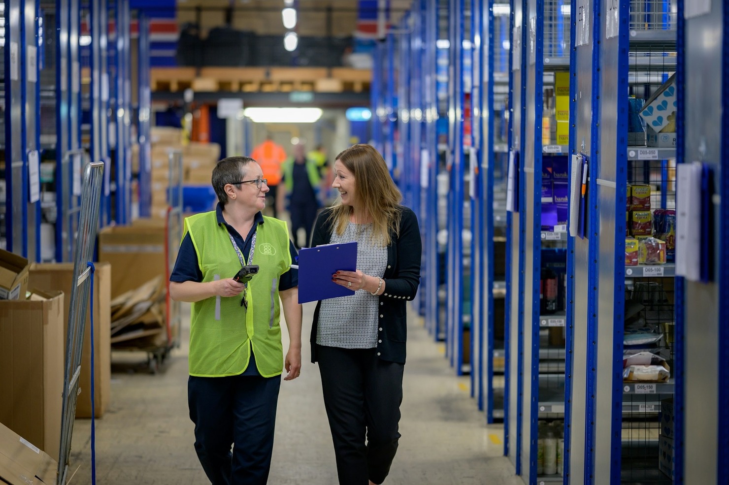 Two women walking through a warehouse and talking
