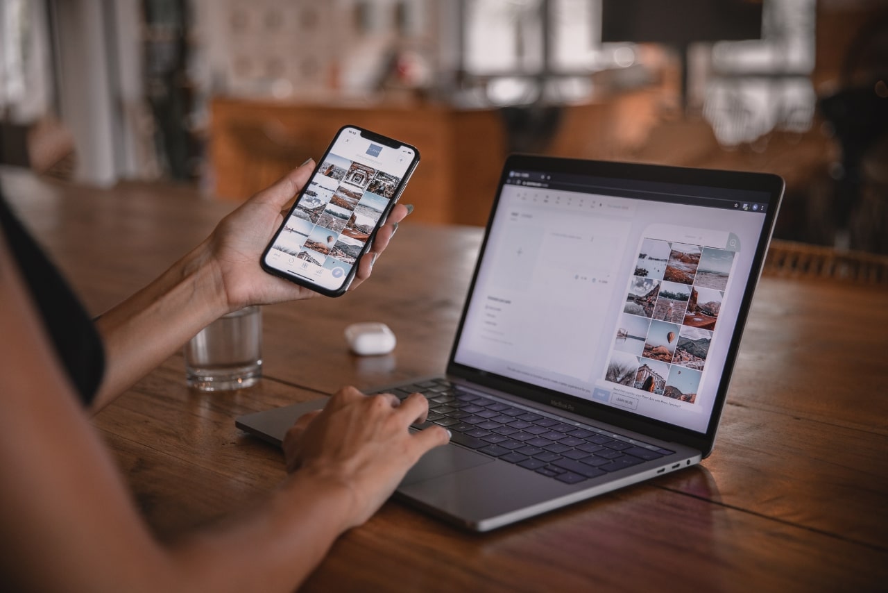 Woman Using Smartphone and Laptop checking for blog comments.