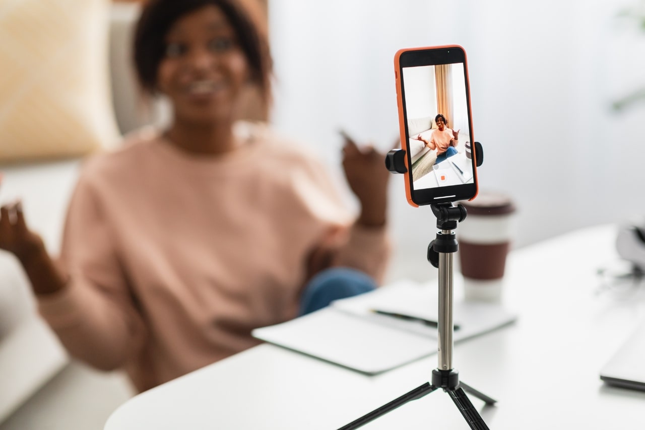 Woman making video using phone creating blog.