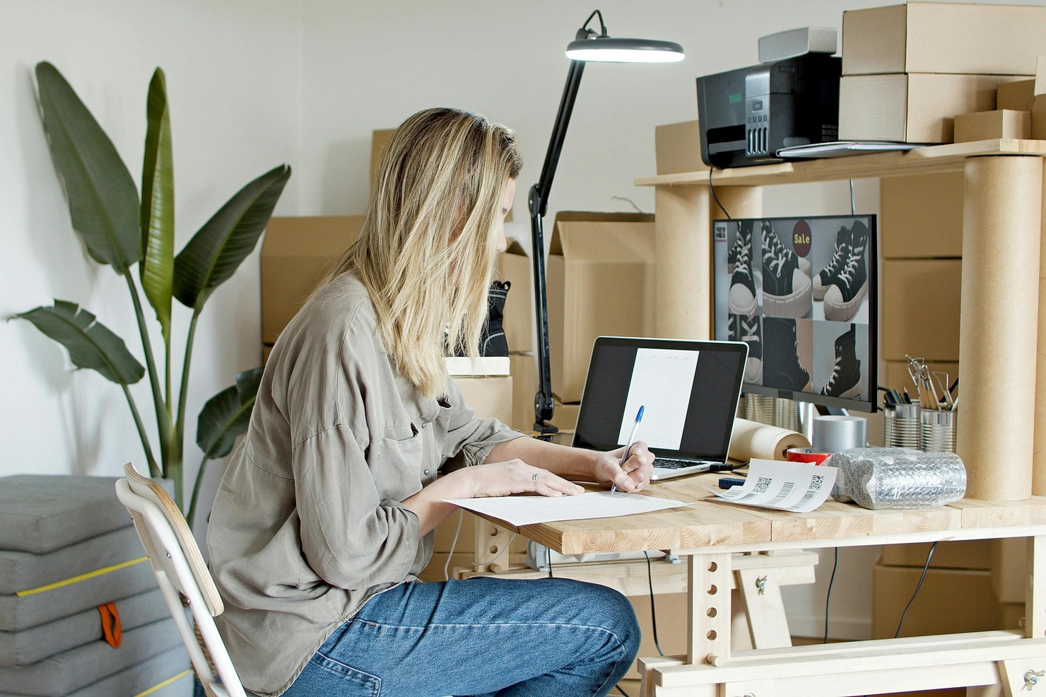 Woman uploading products and writing descriptions for her e-commerce business.