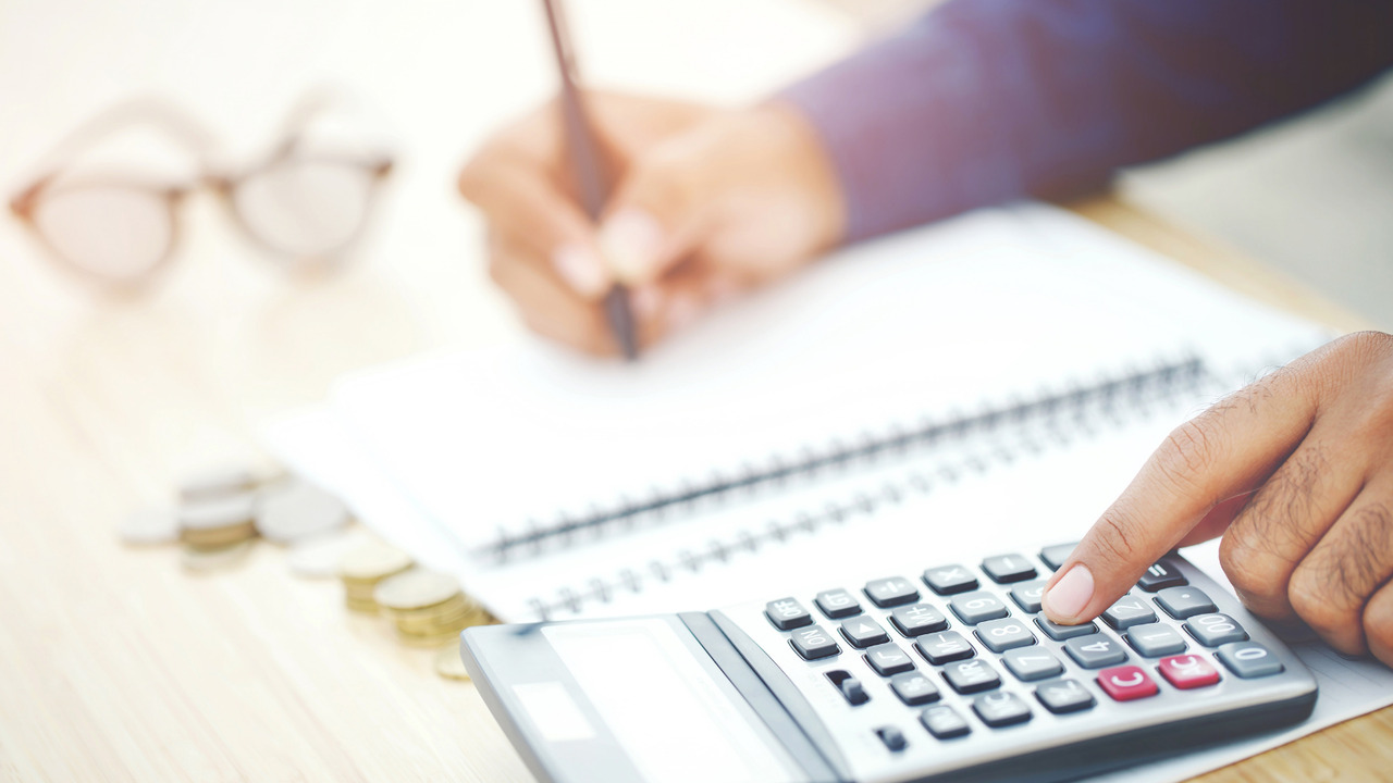 Man budgeting with a calculator and notebook.
