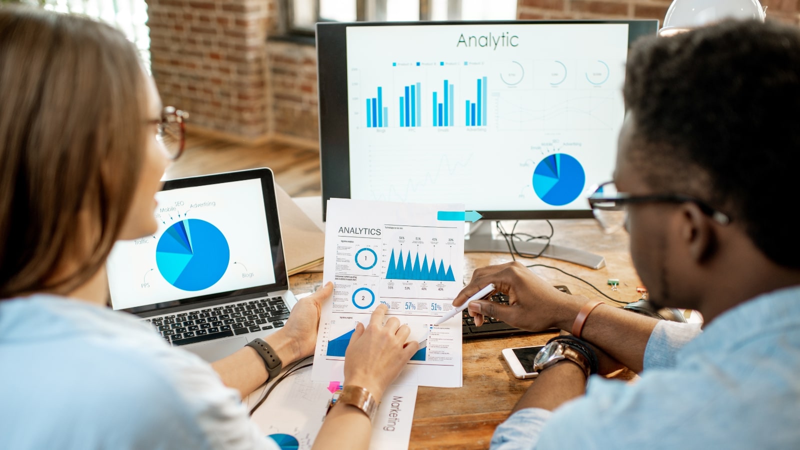 Businessman and woman analyzing and checking metrics for website.