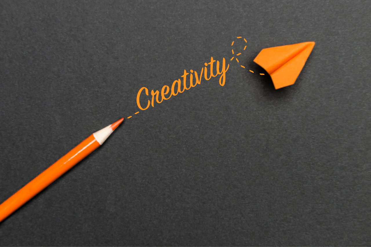 An orange pencil writes the word 