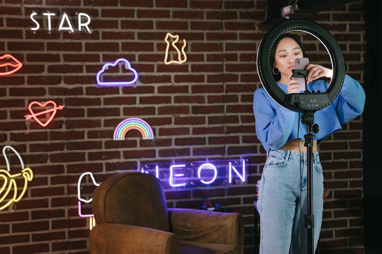 A woman using her phone attached to a ring light