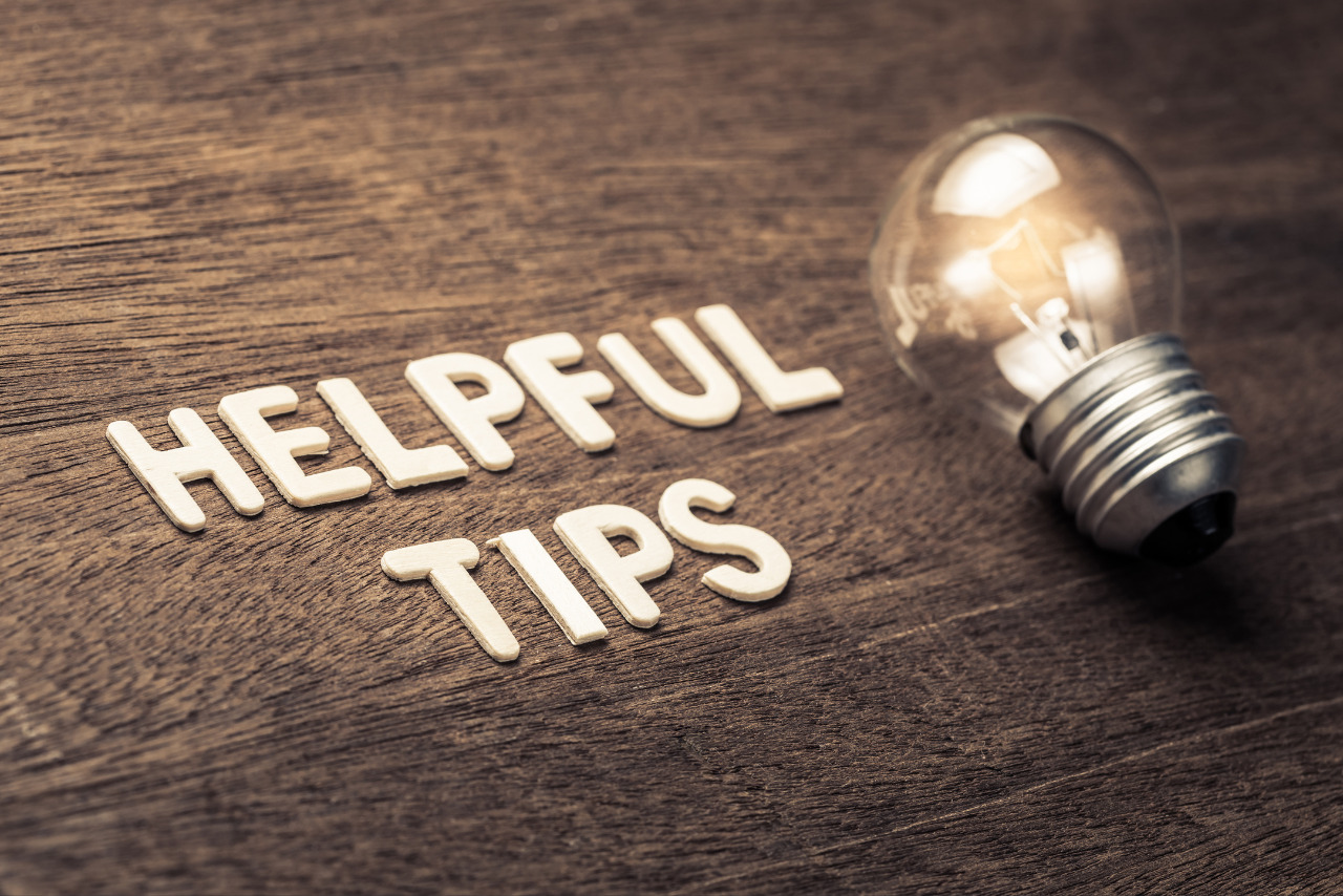 Helpful tips word with glowing lightbulb on wooden table.