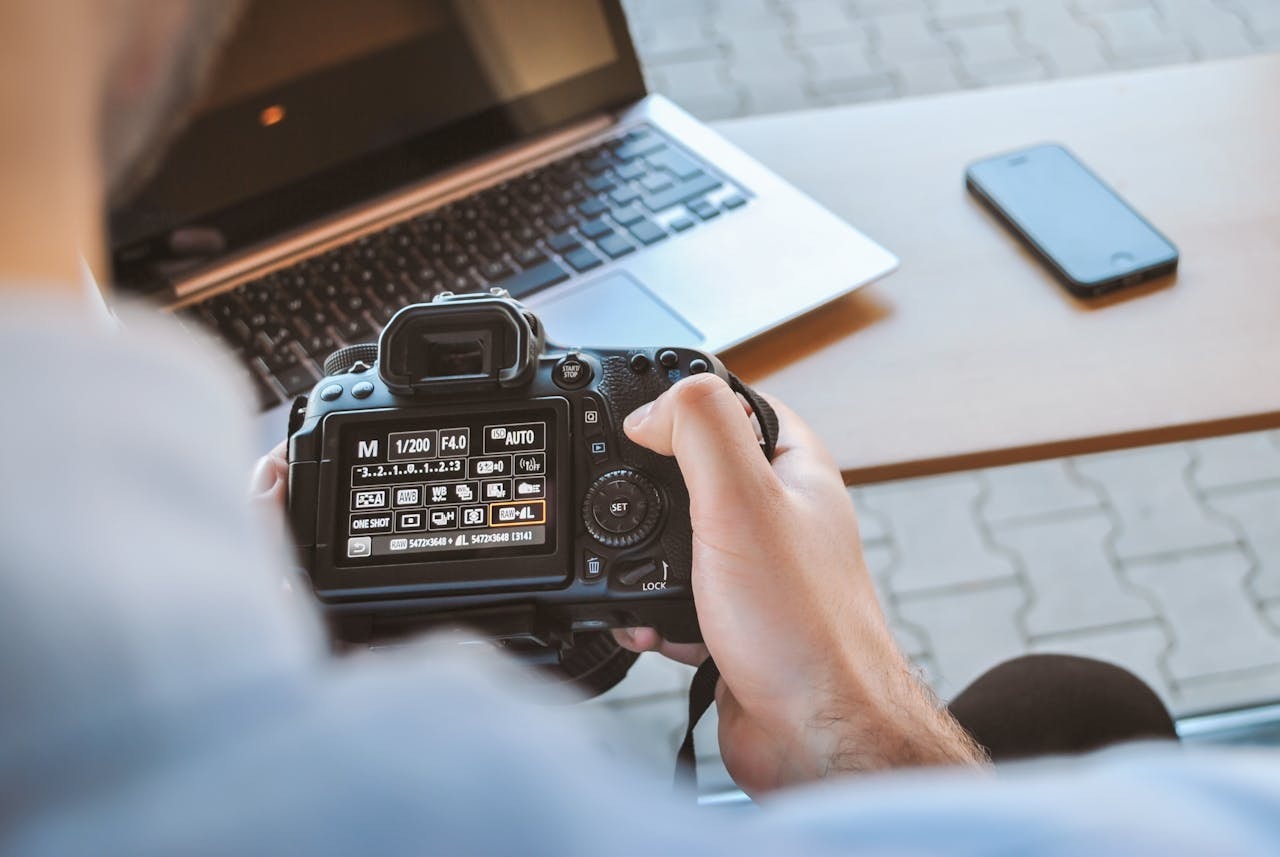 A man looking at camera settings on a DSLR