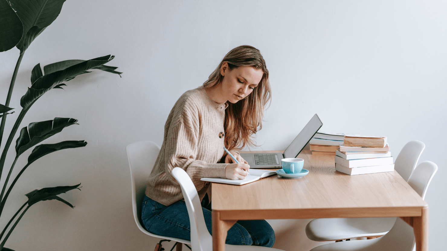 Female focused at writing on her notebook.
