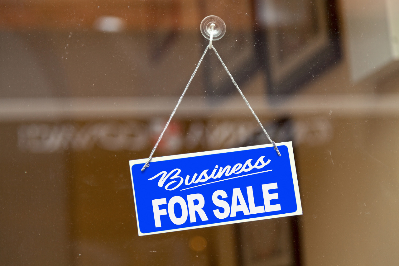 Business for sale sign hanging on glass door.