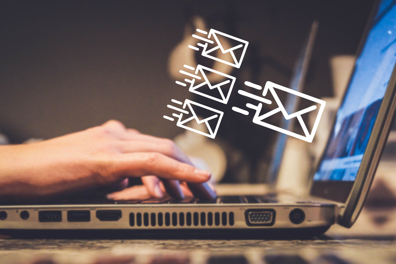 Hands typing and sending emails.