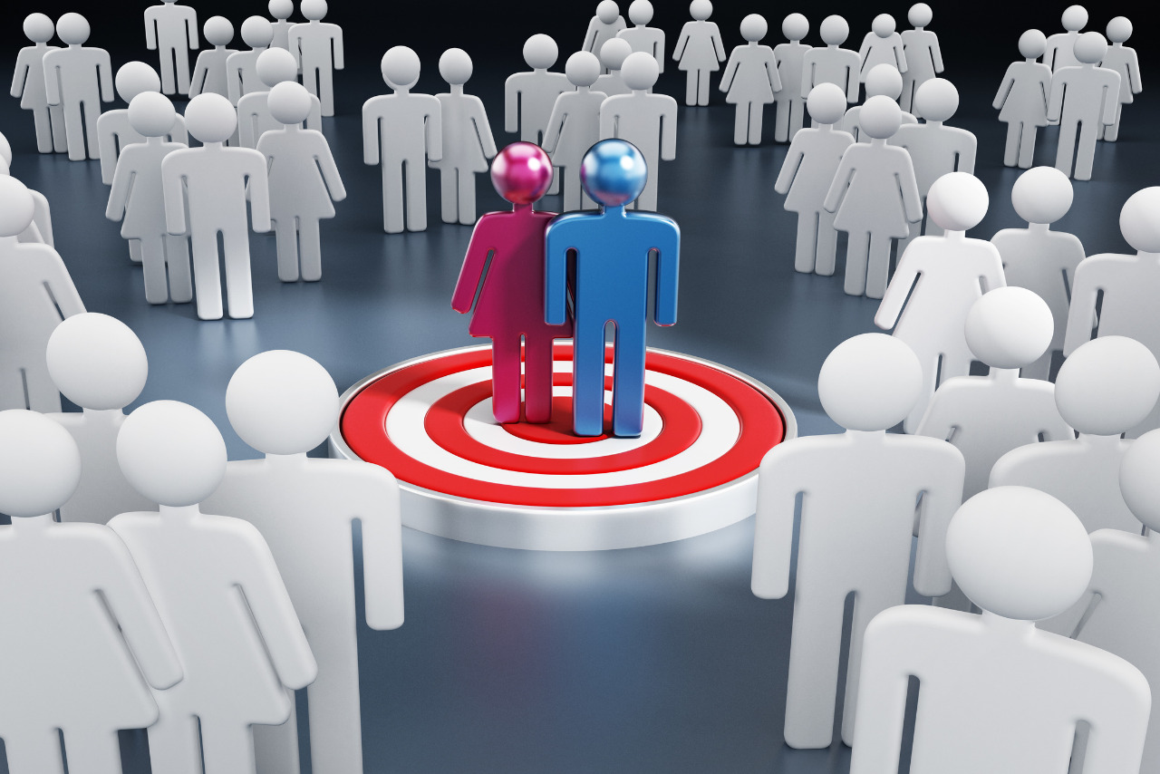 Colored figures standing at the center of target among white ones.