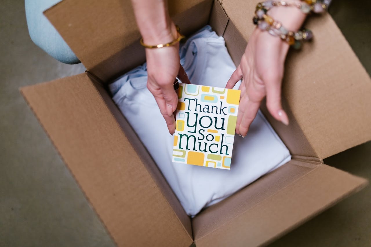 A person putting a thank-you card into a package