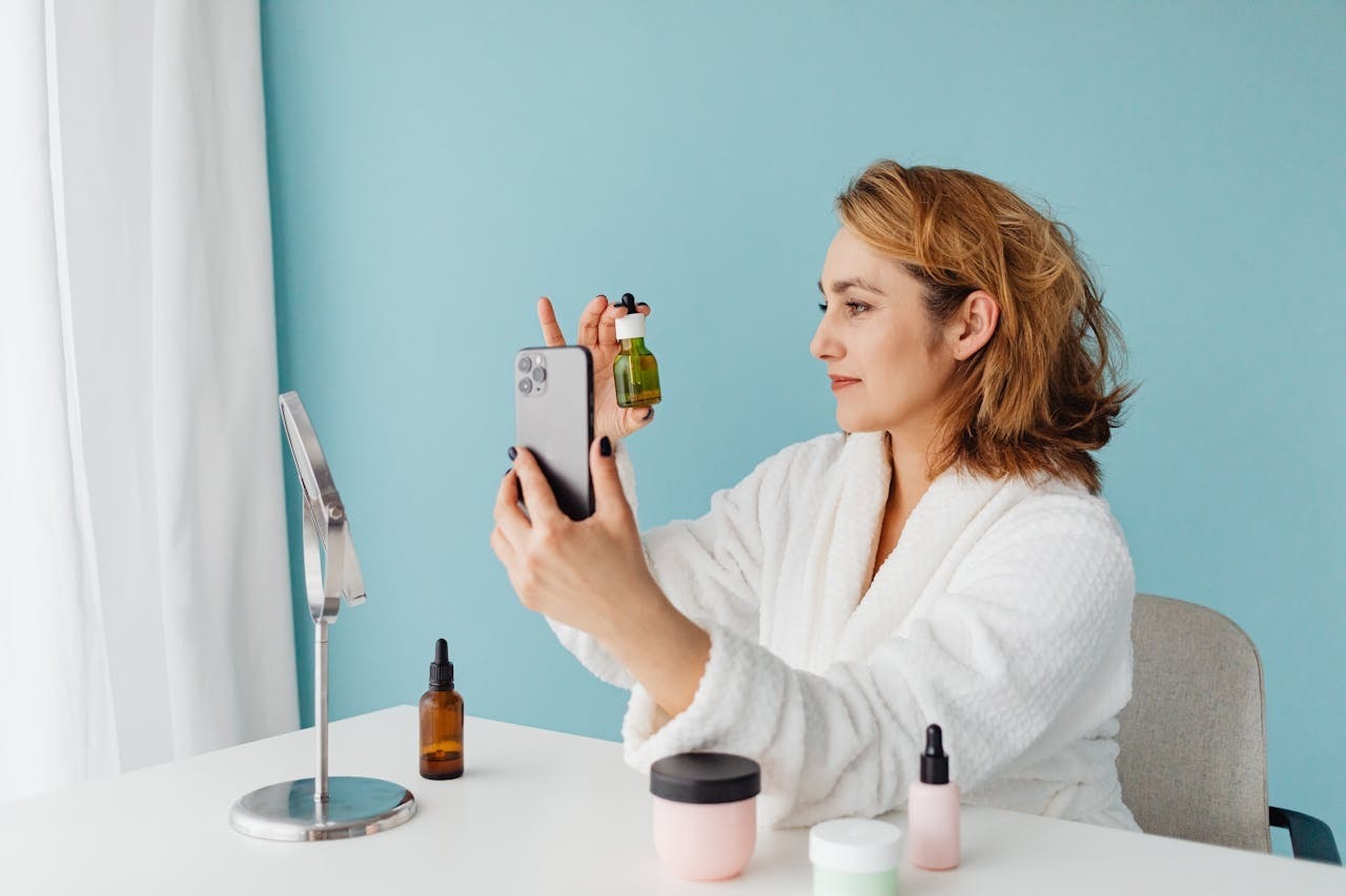 A woman taking a picture of a cosmetic bottle using a mobile phone