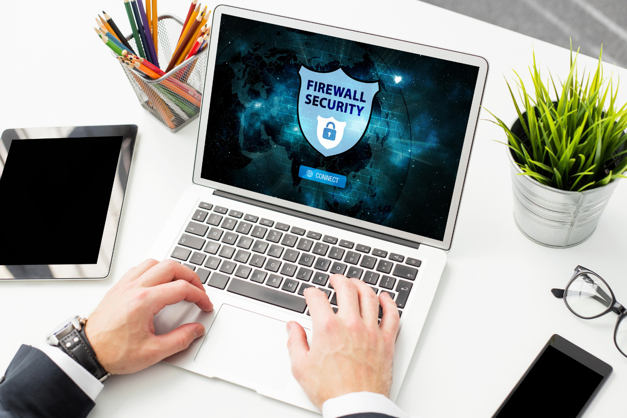 Man Using Firewall Protection Software on Laptop.