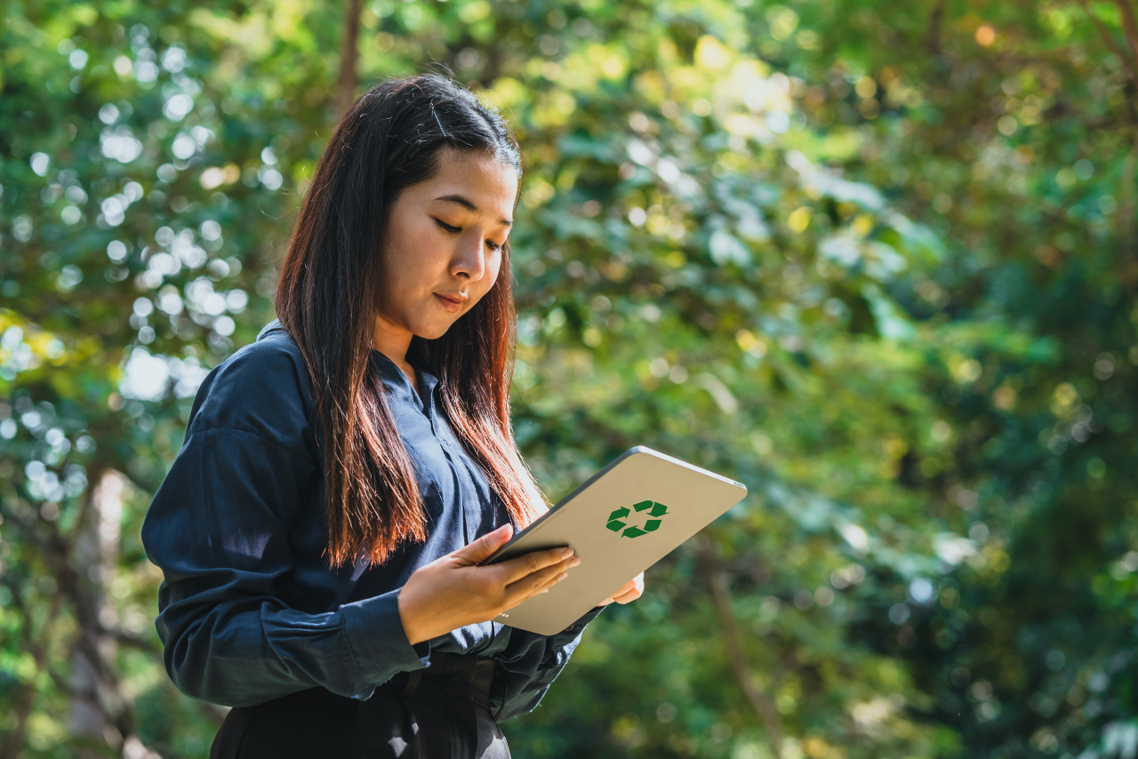 A female Sustainability Consultant holding tablet with recycle icon at the back.