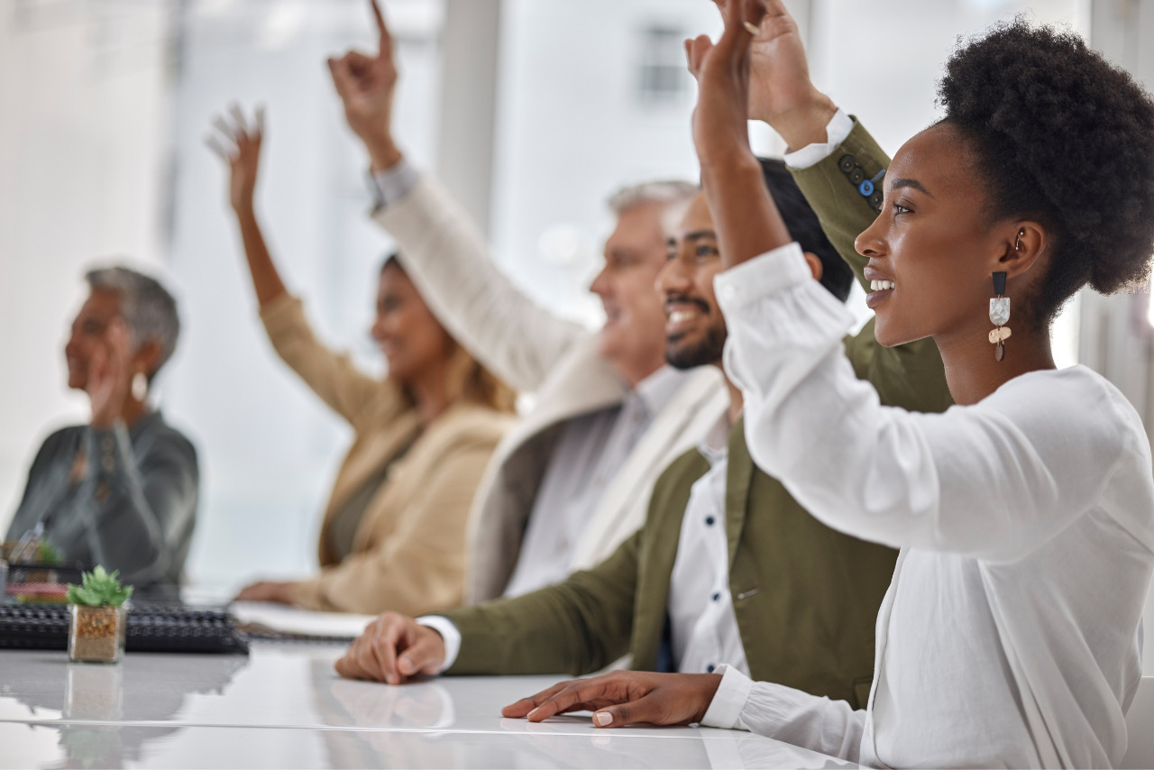 A group of participants raising hands to ask questions.