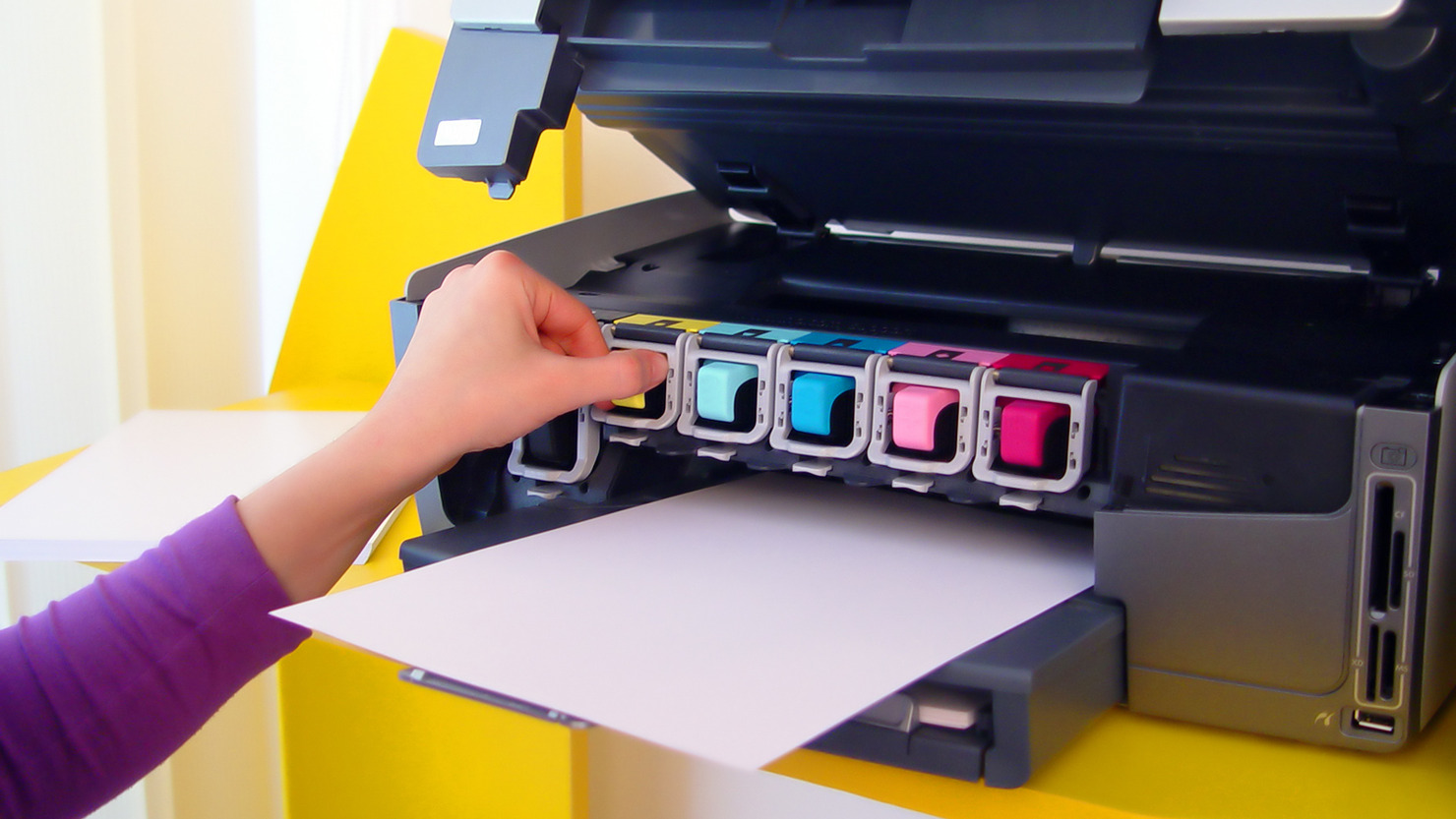 Woman refilling ink on a printer.