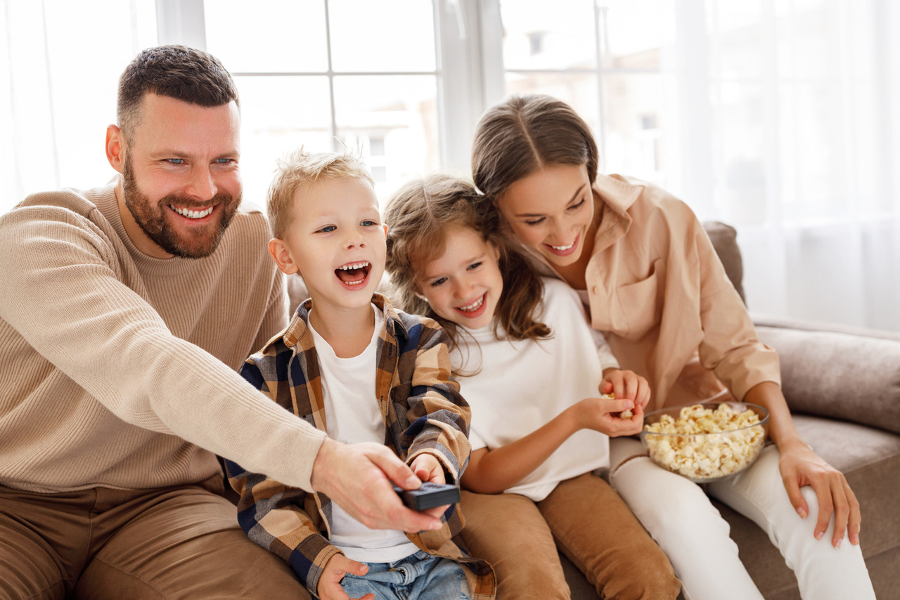 Happy family watching tv together.