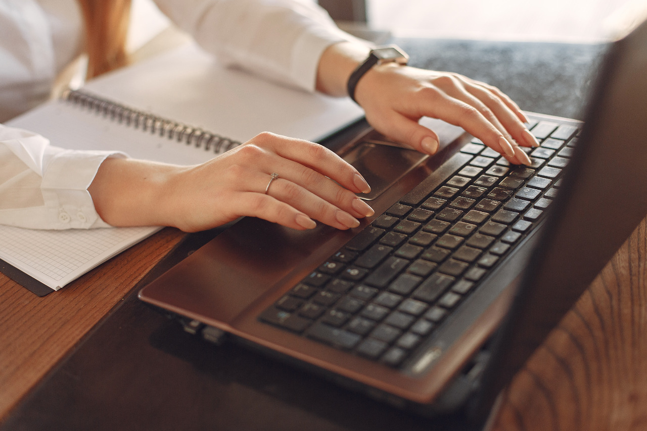 Woman crafting guest post on her black laptop computer.