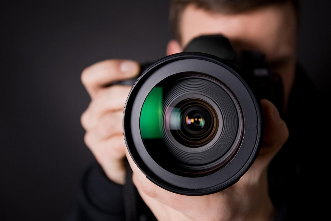 Photographer holding black camera front view.