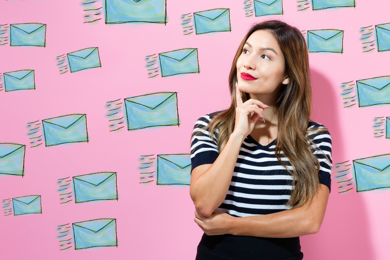 Woman contemplating surrounded by email icons.
