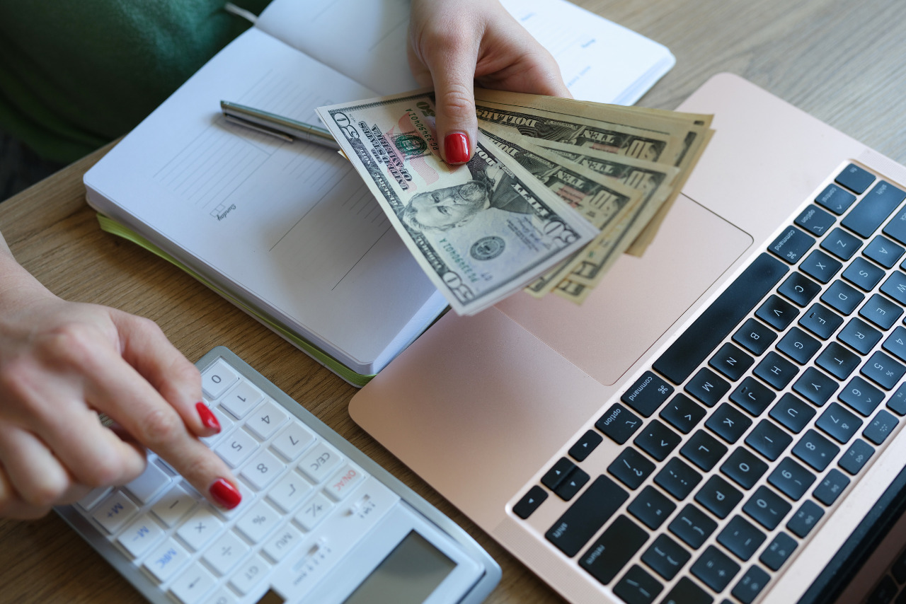 A woman planning her budget by calculating deductions using a calculator.