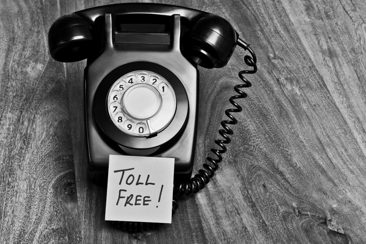 Retro black and white telephone with toll free message.