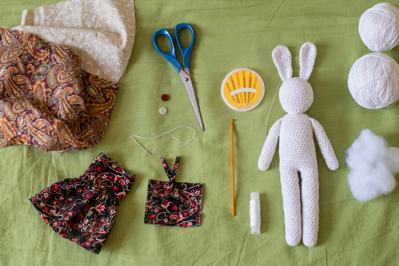 Materials for crafting a handmade crochet rabbit toy arranged on a table.