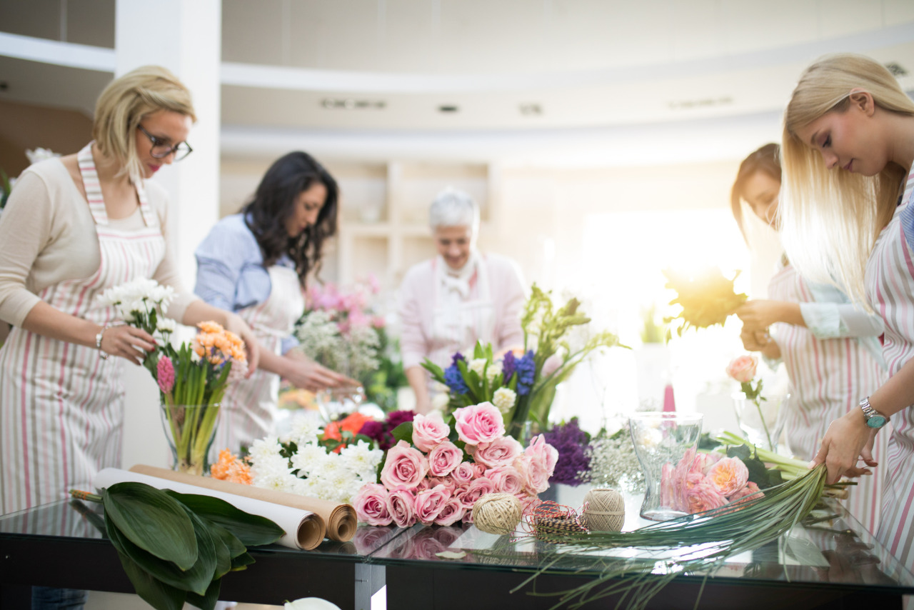 A group of women arranging flower bouquets at a workshop.