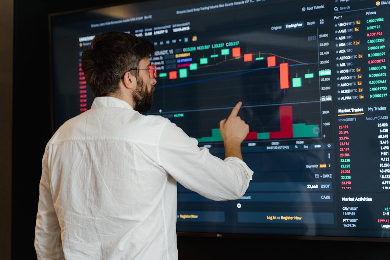 A man analyzing market data displayed on a screen