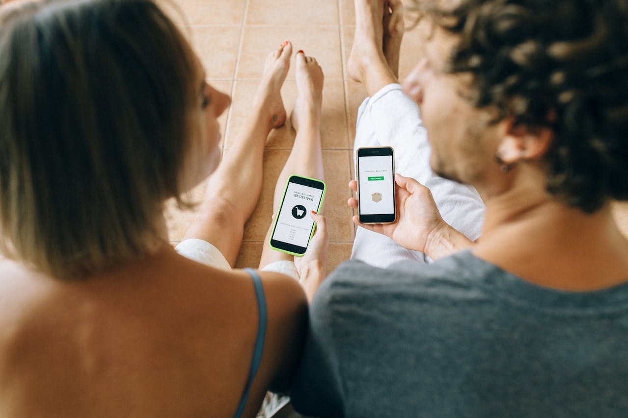 A man and woman doing online shopping with their mobile phones