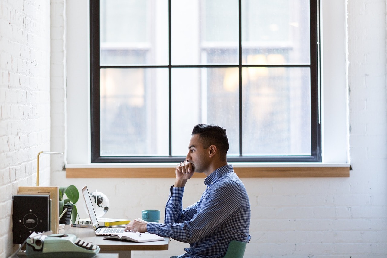 A man looking intently at a laptop screen