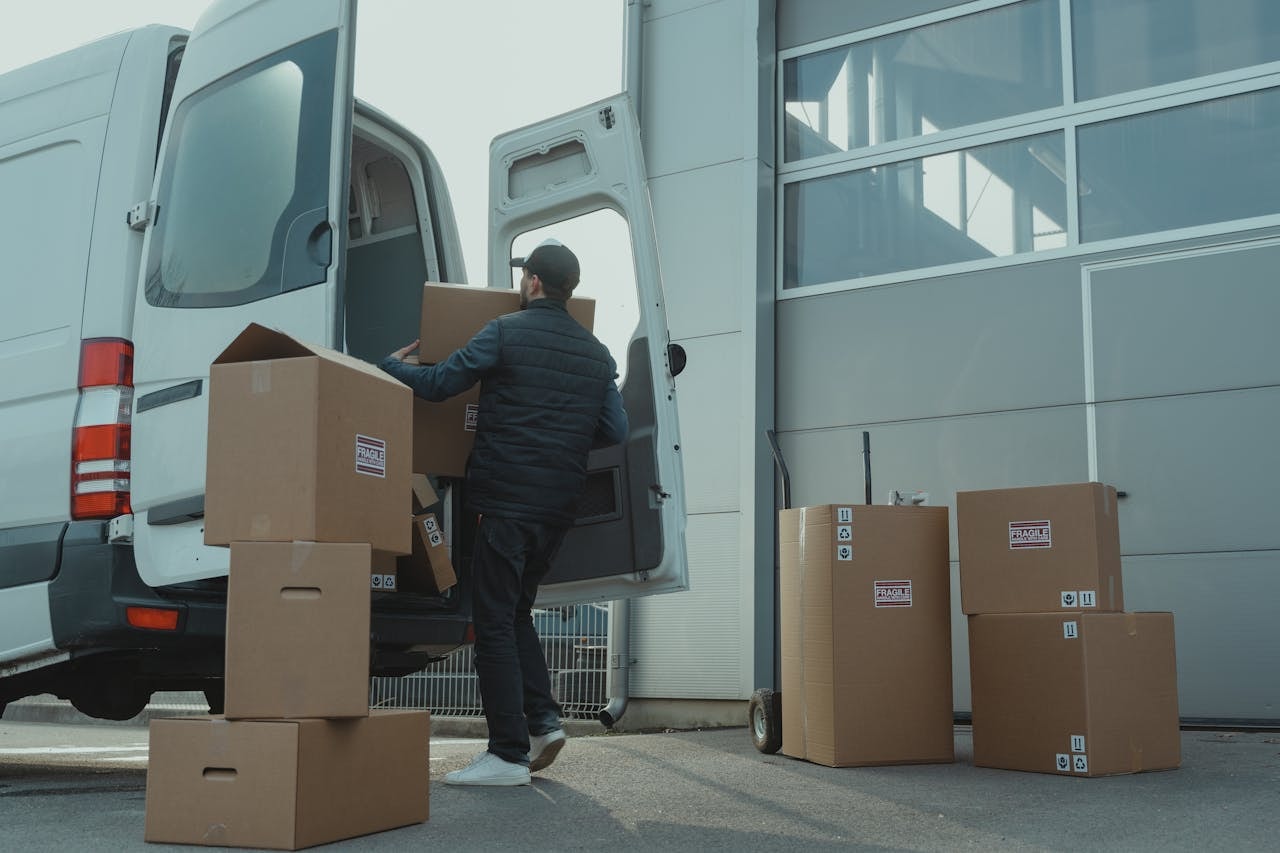 A man putting boxes for delivery to a van