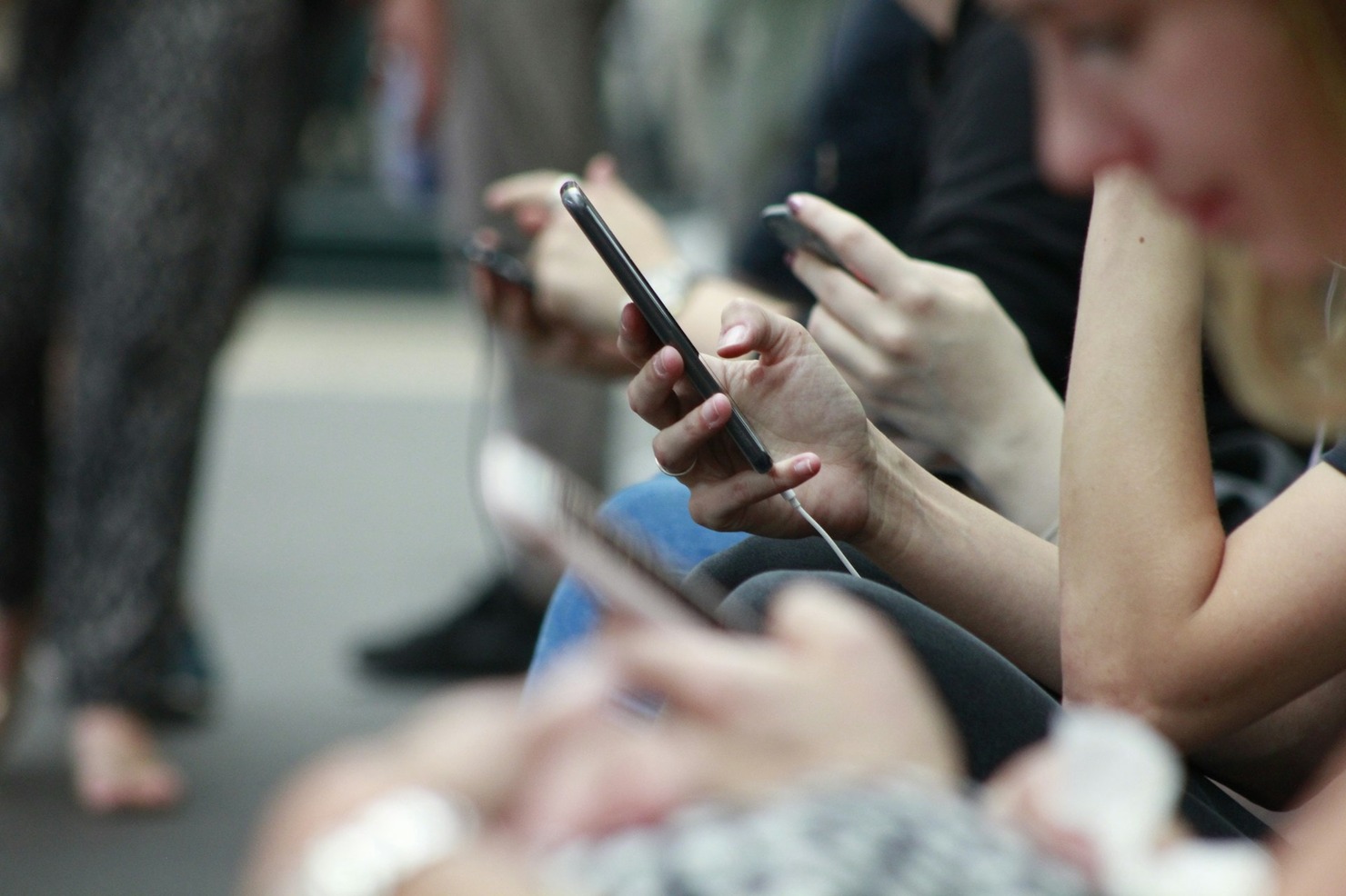 A row of people using mobile phones