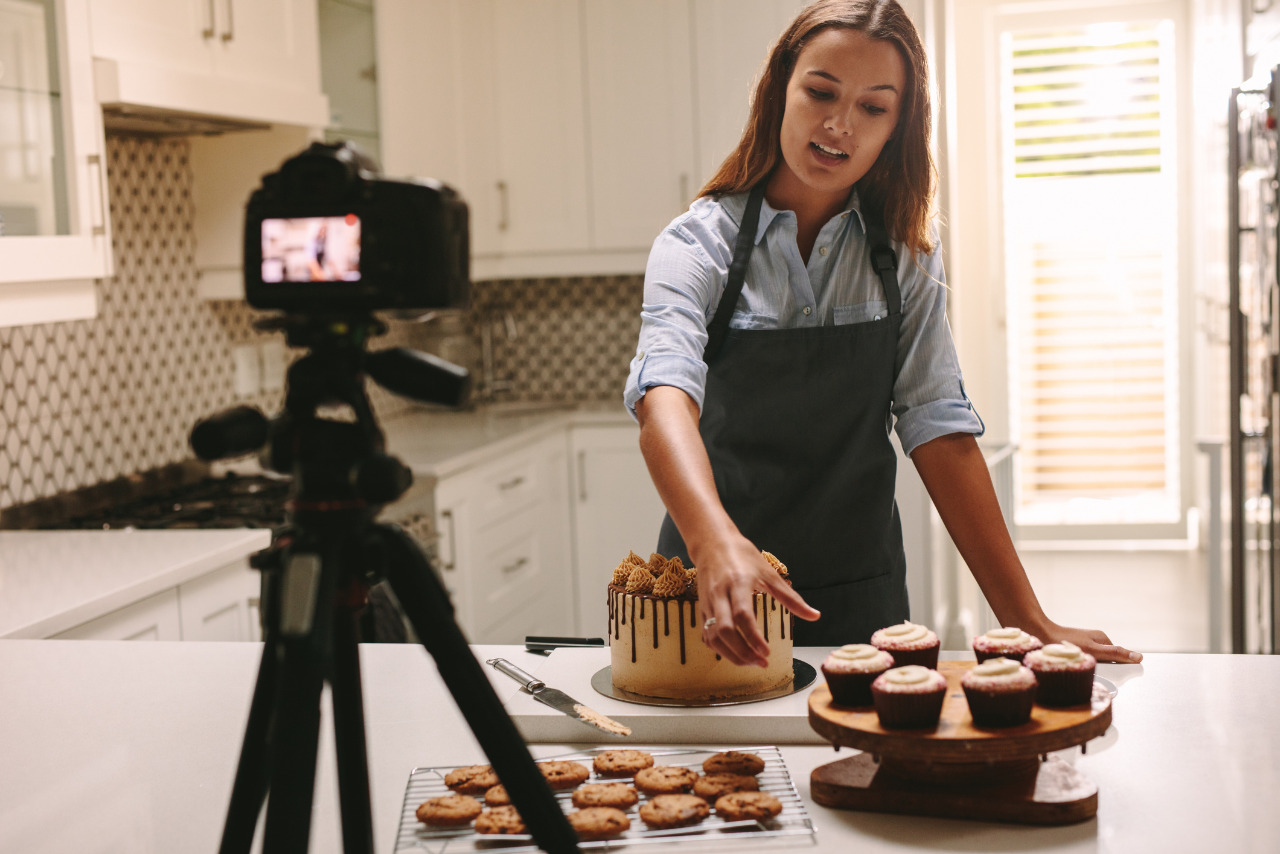 A woman blogging and recording herself while baking.