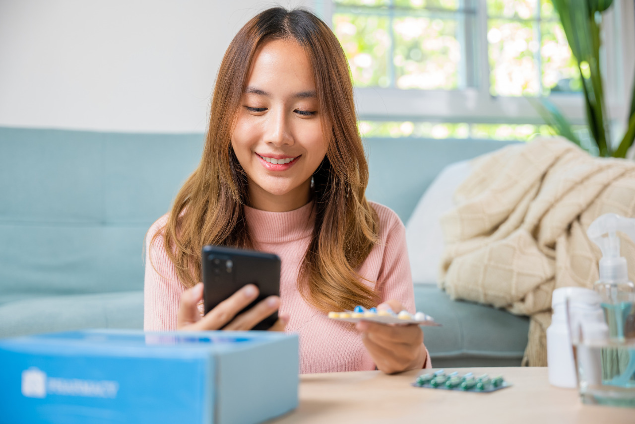 A woman reading the side effects of an online-purchased capsule.