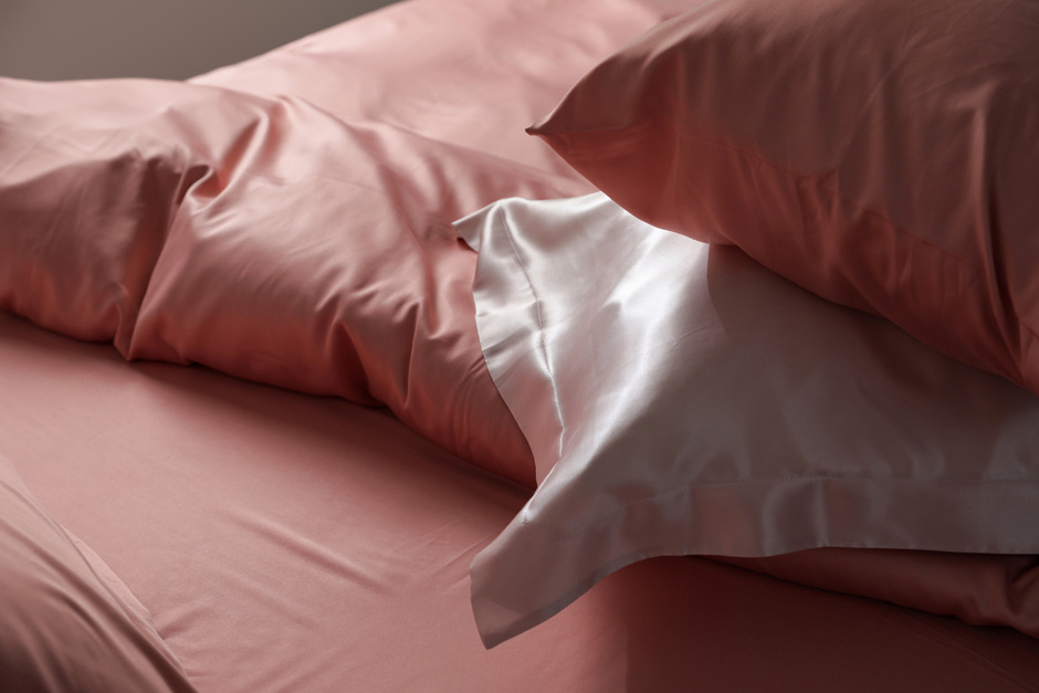 Bed with beautiful silk pillows and linens.