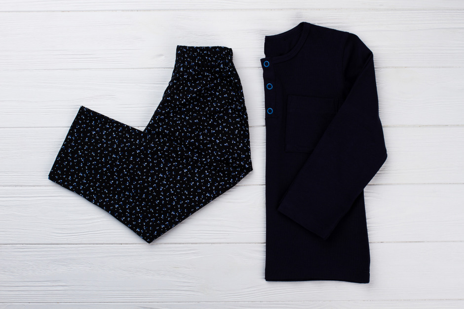 Black pajama set on white wooden background.
