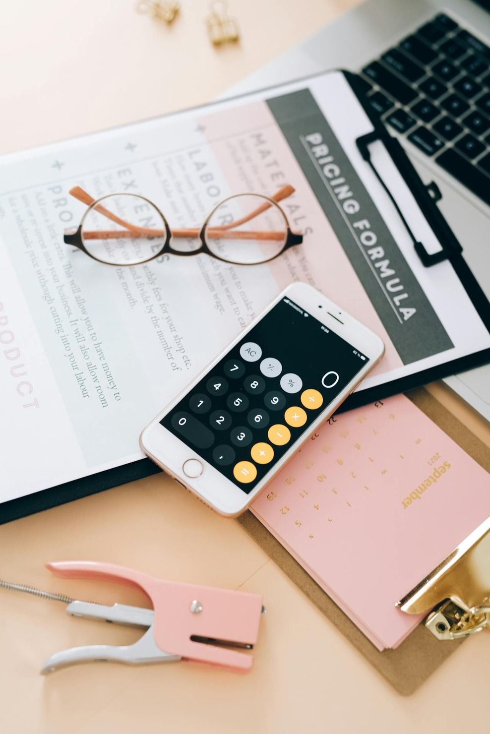 Document on a clipboard with eyeglasses and a calculator placed on top of it